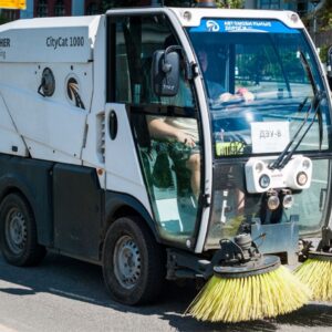 Gebäudereiniger mit Maschine auf Gehweg in Salzburg bei der fachgerechten Flächenreinigung