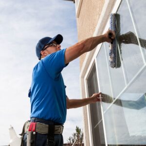 Gebäudereiniger mit Sonnenschutzkleidung bei sommerlicher Fassadenreinigung